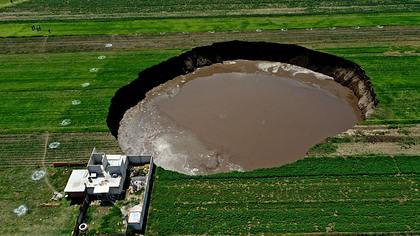 Krater von Zacatepec, angrenzendes Haus, Luftaufnahme - Foto: Getty Images / JOSE CASTANARES