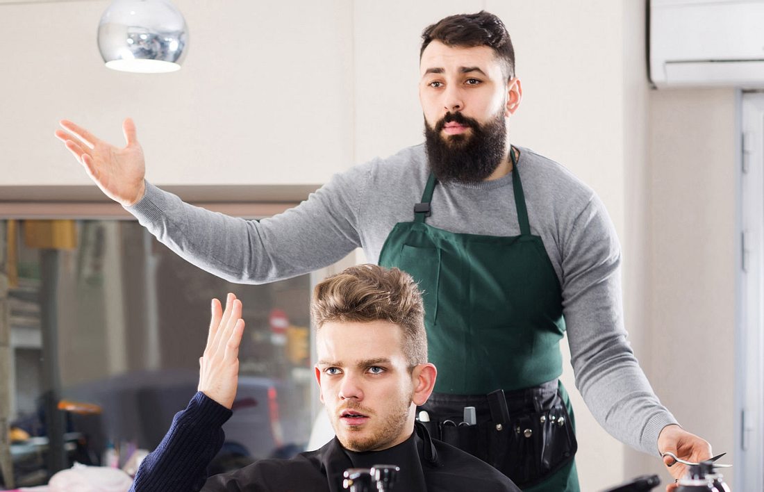 Junger Mann beschwert sich bei Friseur über Haarschnitt