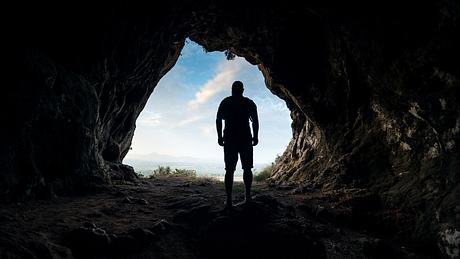 Mann in einem Höhleneingang - Foto: iStock / sankai