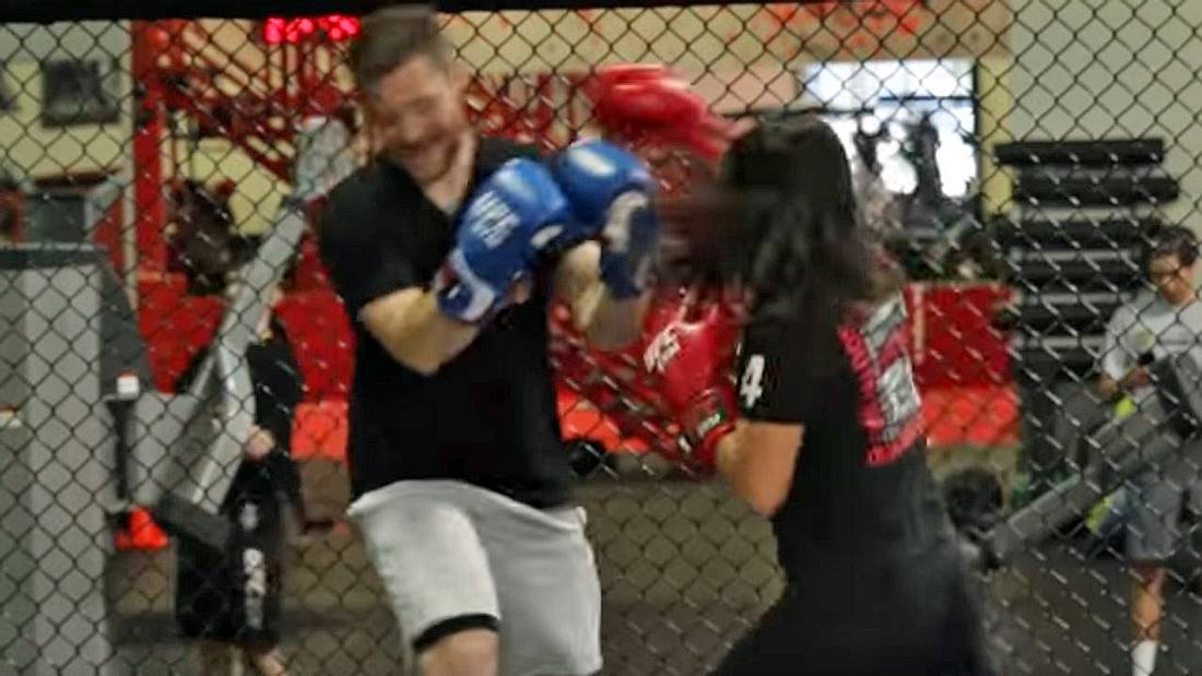 Ein in MMA trainiertes Mädchen kämpft gegen einen erwachsenen Mann