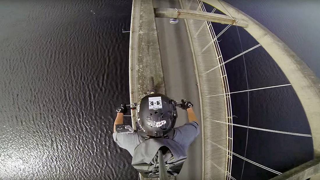 GoPro-Video: Ein Motocross-Fahrer des Stunt Freaks Team filmte, wie er auf dem Bogen einer Brücke einen Fluss überquert Ein Motocross-Fahrer des Stunt Freaks Team überquert eine Brücke auf dem Brückenbogen