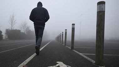 Mann geht auf einem Asphaltweg - Foto: GettyImages/ DAMIEN MEYER