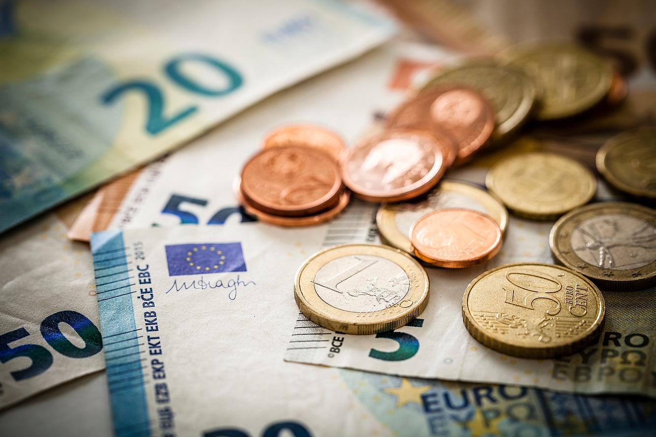 Niedrigere Löhne durch Corona Geld in Münzen und Scheinen