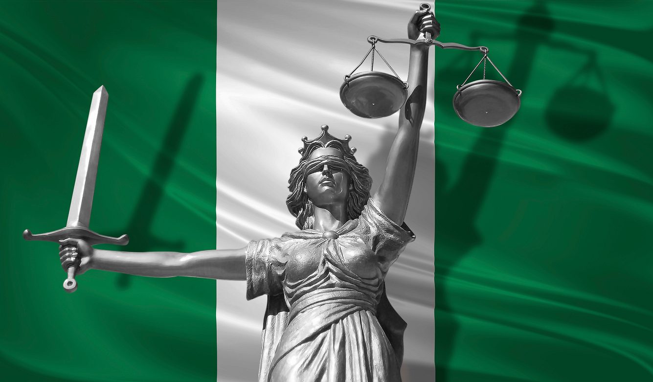 Nigeria legalisiert Kastration für Vergewaltiger Statue des Gottes der Gerechtigkeit Themis vor der Flagge Nigerias