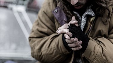 Obdachloser reibt sich die Hände - Foto: iStock / KatarzynaBialasiewicz