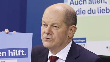 Olaf Scholz miz Plakat der Impfkampagne  - Foto: Imago / Metodi Popow