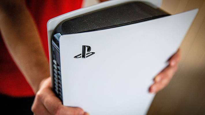 Mann hält ausgepackte PlayStation 5 in den Händen - Foto: IMAGO / ANP