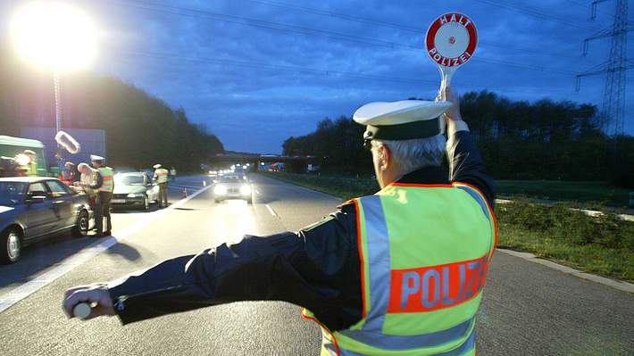 Verkehrskontrolle, Polizist mit Warnkelle - Foto: IMAGO / Udo Gottschalk