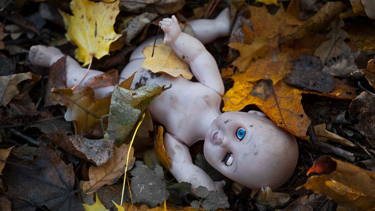 Creepy Puppe auf dem Waldboden