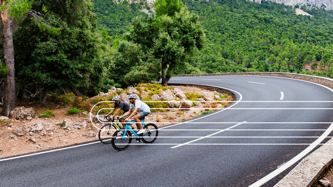 Zwei Radfahrer fahren auf einer Straße auf Mallorca 
