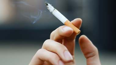 Brennende Zigarette in Hand - Foto: iStock / fuzznails