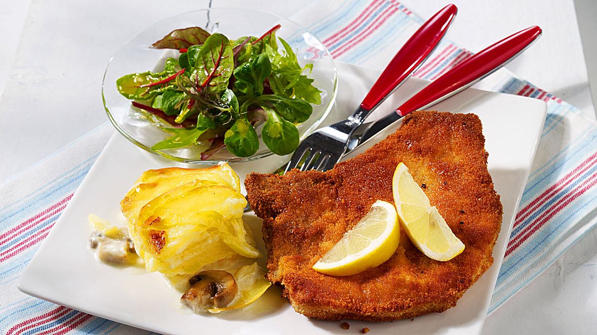 Paniertes Kotelett mit Pilz-Kartoffel-Gratin und Babysalat