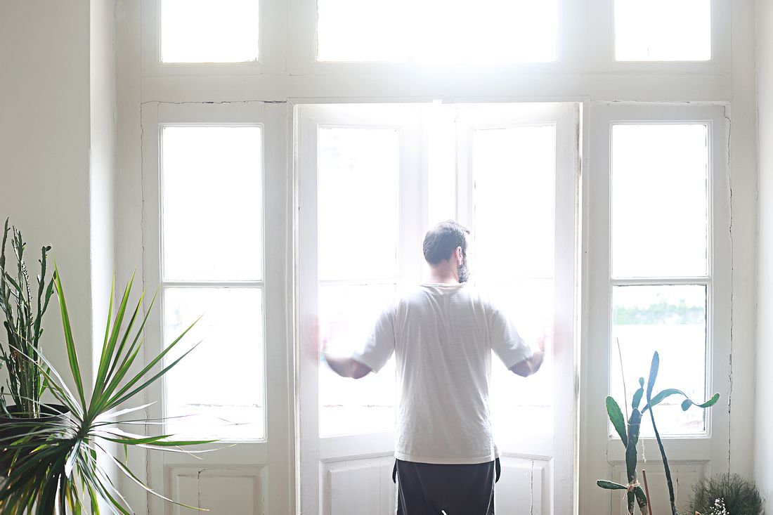 Richtig lüften: So sorgst du für gute Luft zu Hause Mann öffnet seine Fenster