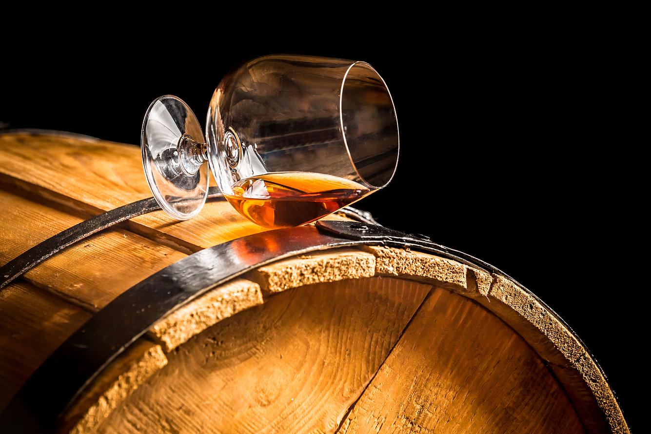 Glas mit Rum auf einem Fass Glas mit Rum auf einem Fass