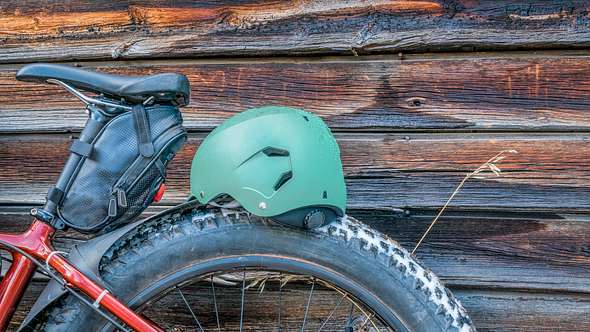 Ein Fahrrad mit Satteltasche steht an eine Holzwand gelehnt - Foto: iStock/marekuliasz