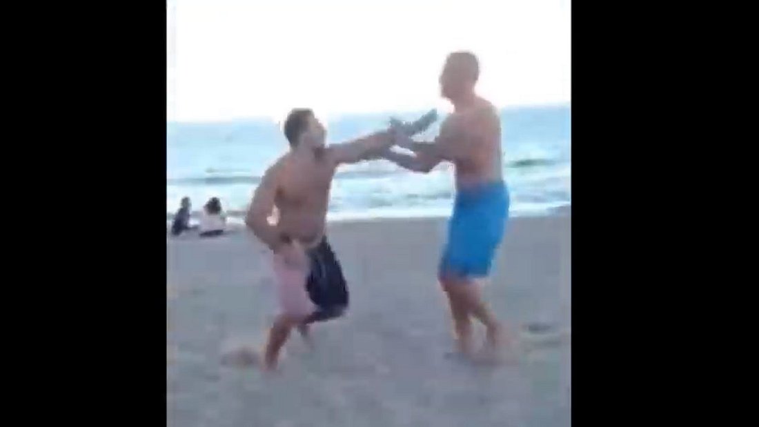 Schlägerei zwischen Betrunkenem und einem Vater am Strand. Schlägerei zwischen Betrunkenem und einem Vater am Strand.