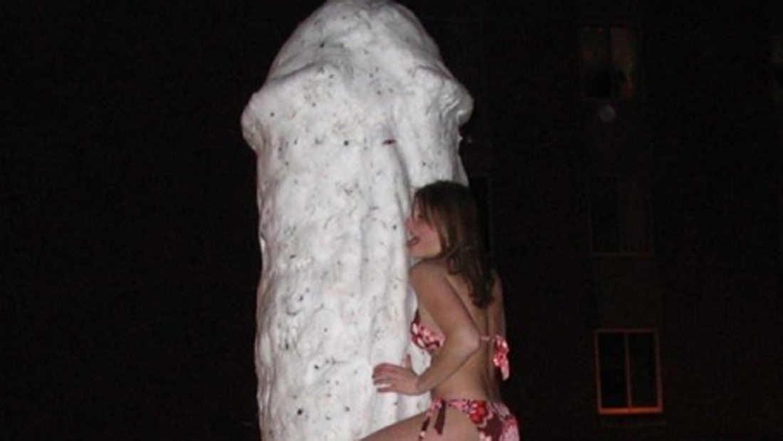 Schnee-Penis: Eine Frau in Bikini posiert am Frost-Phallus