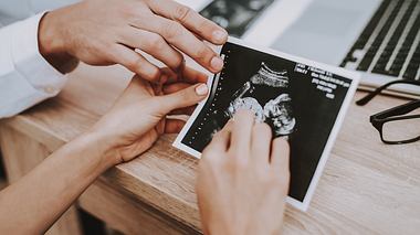 Frau hält Ultraschall-Bild ihres Babys in den Händen - Foto: iStock / vadimguzhva