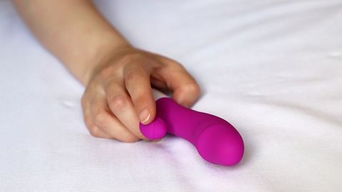 Weibliche Hand umklammert pinken Vibrator  - Foto: istock/Oleg Elkov