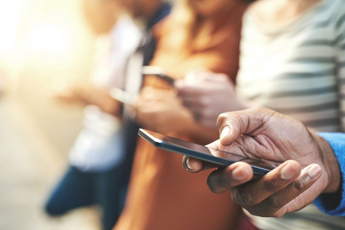Smartphone-App soll Coronavirus stoppen Mehrere Personen mit Smartphones in den Händen