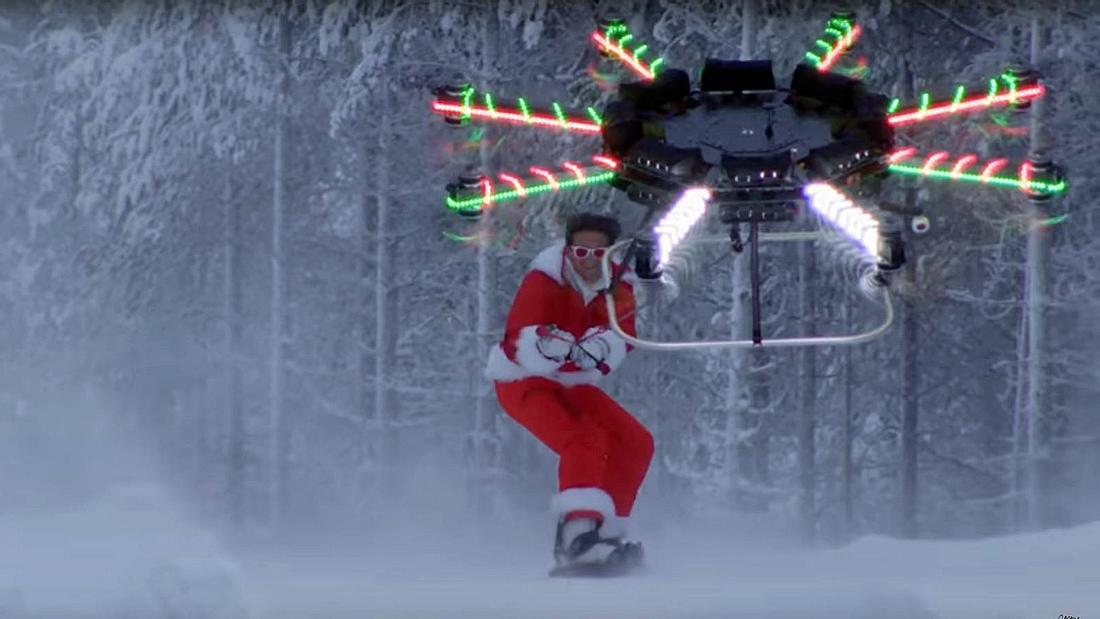 Ein Snowboarder lässt sich von einer Drone eine Skipiste herunterziehen