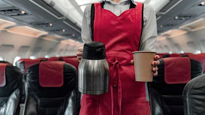 Stewardess mit Kaffee in der Hand - Foto: iStock / YakobchukOlena