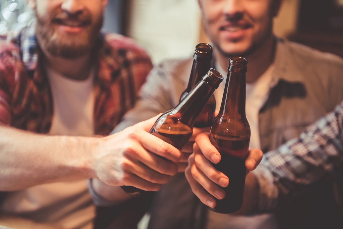 Männer stoßen mit Bierflaschen an