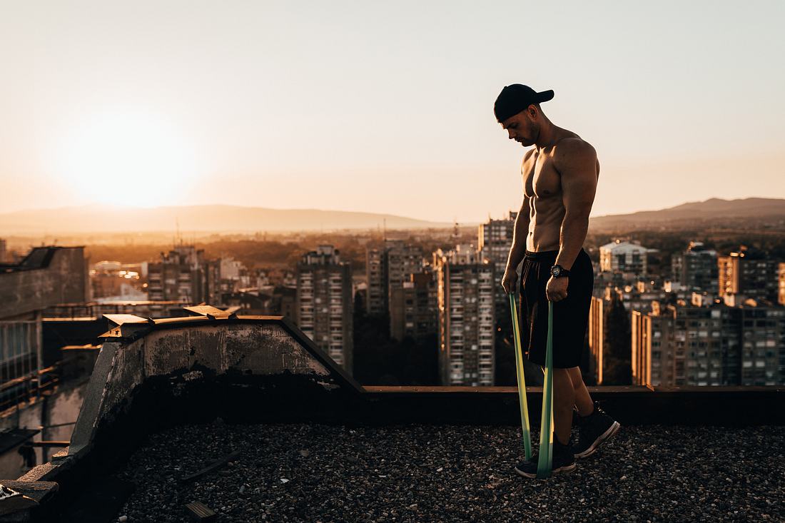 Theraband kaufen Ein Mann trainiert mit Theraband