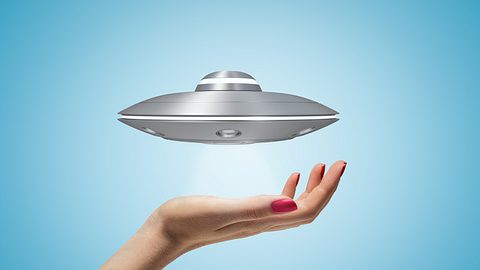 Frauenhand und UFO - Foto: iStock/Gearstd