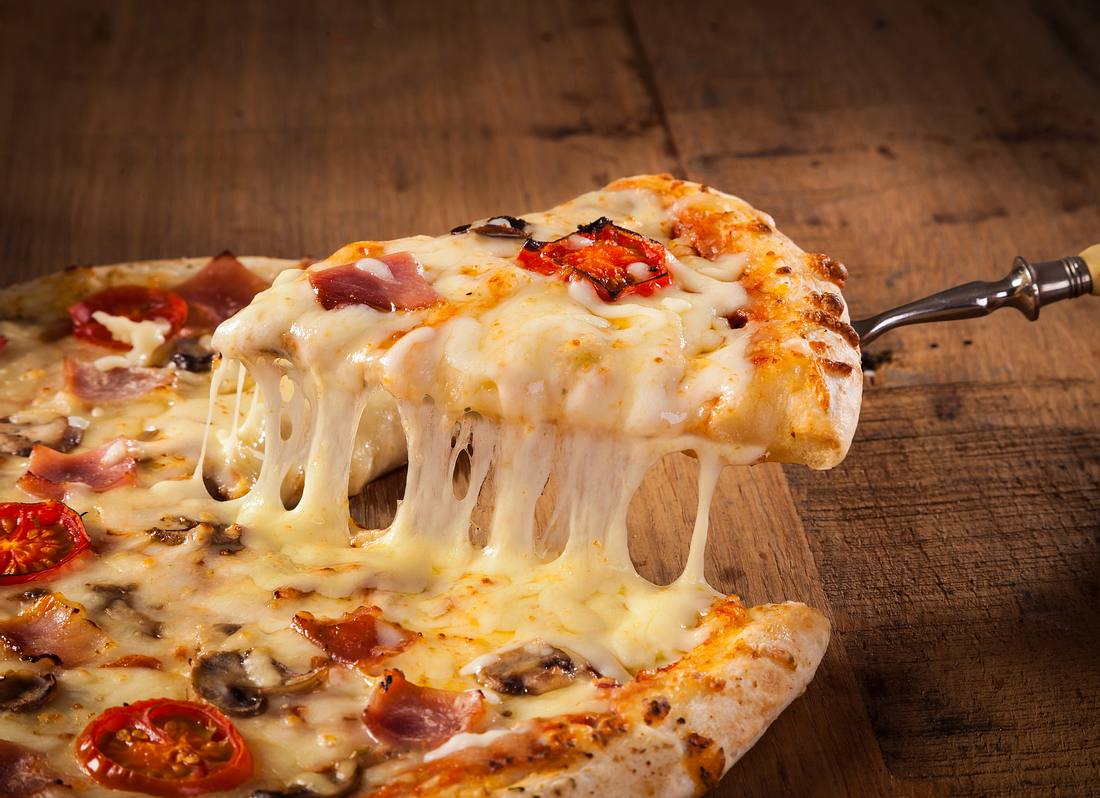 Was gibt es leckereres als Pizza? Ein Stück wird aus der Gesamtpizza gehoben