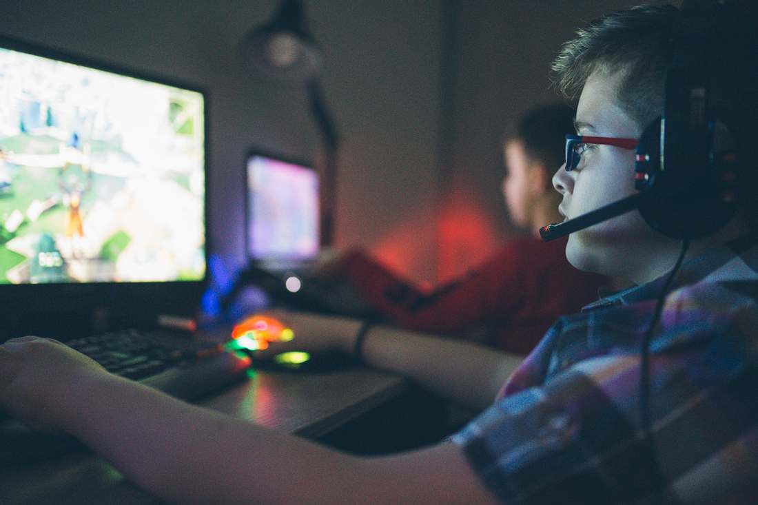 2 Jungs spielen online Games und tragen Headsets