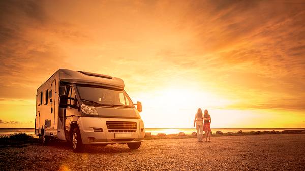 Pärchen vor Sonnenuntergang am Strand - inklusive Wohnmobil - Foto: iStock/by-studio