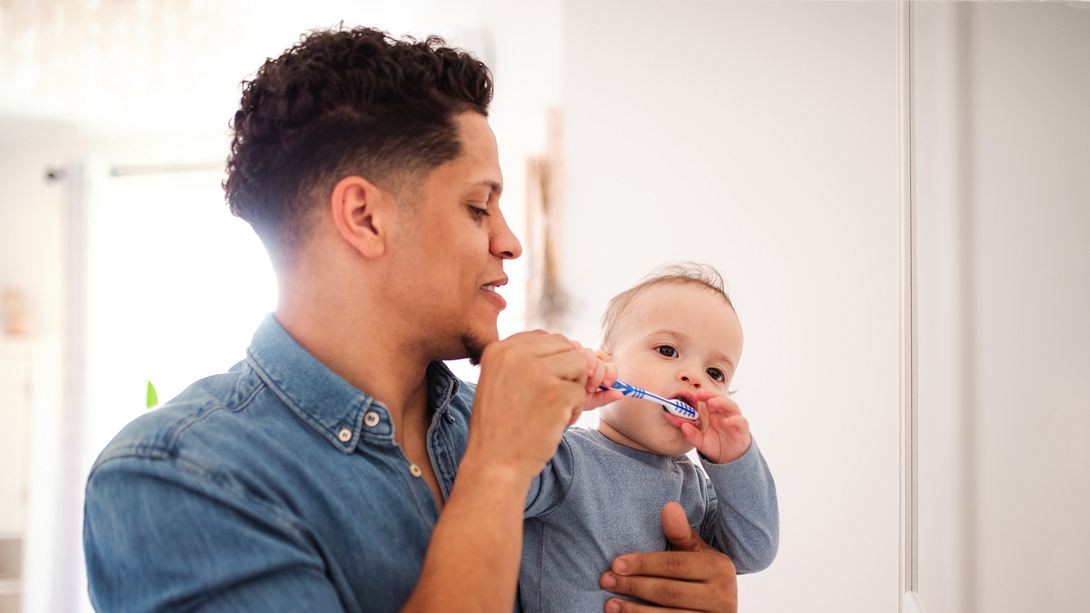 Vater putzt Baby Zähne - Foto: iStock/Halfpoint