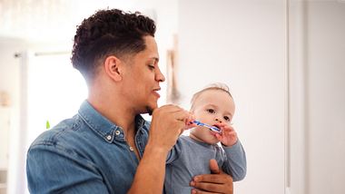 Vater putzt Baby Zähne - Foto: iStock/Halfpoint